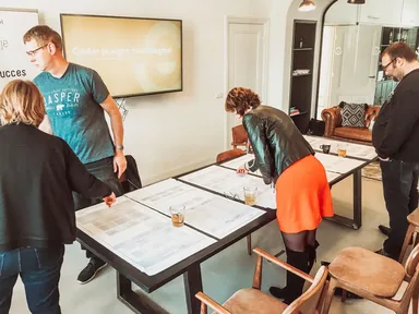 Deelnemers leggen papieren blokken op tafel